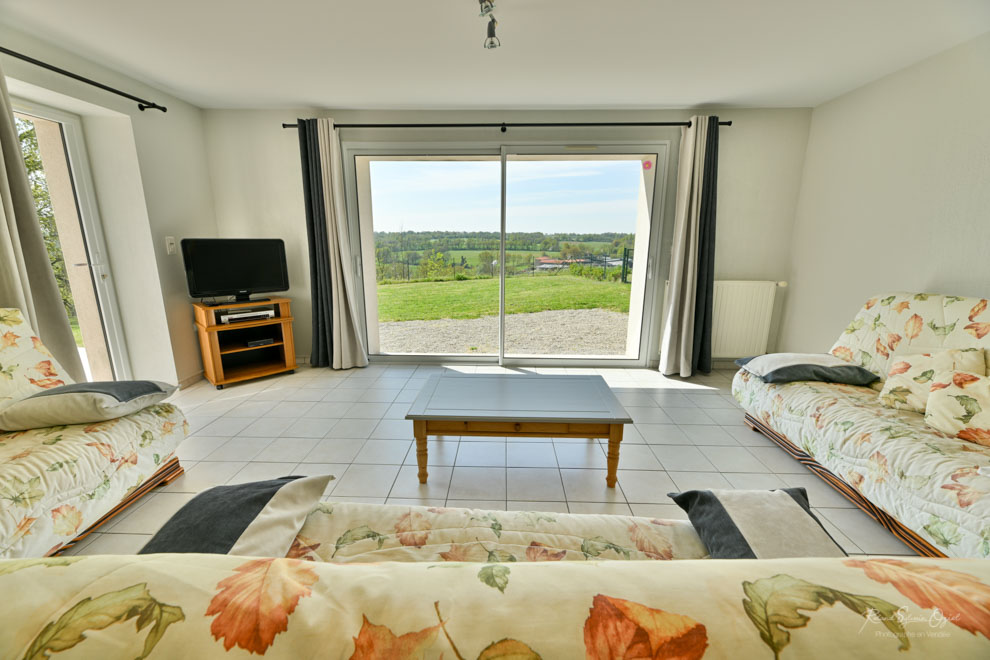 Salle de séjour avec grande baie vitrée et vue sur la vallée